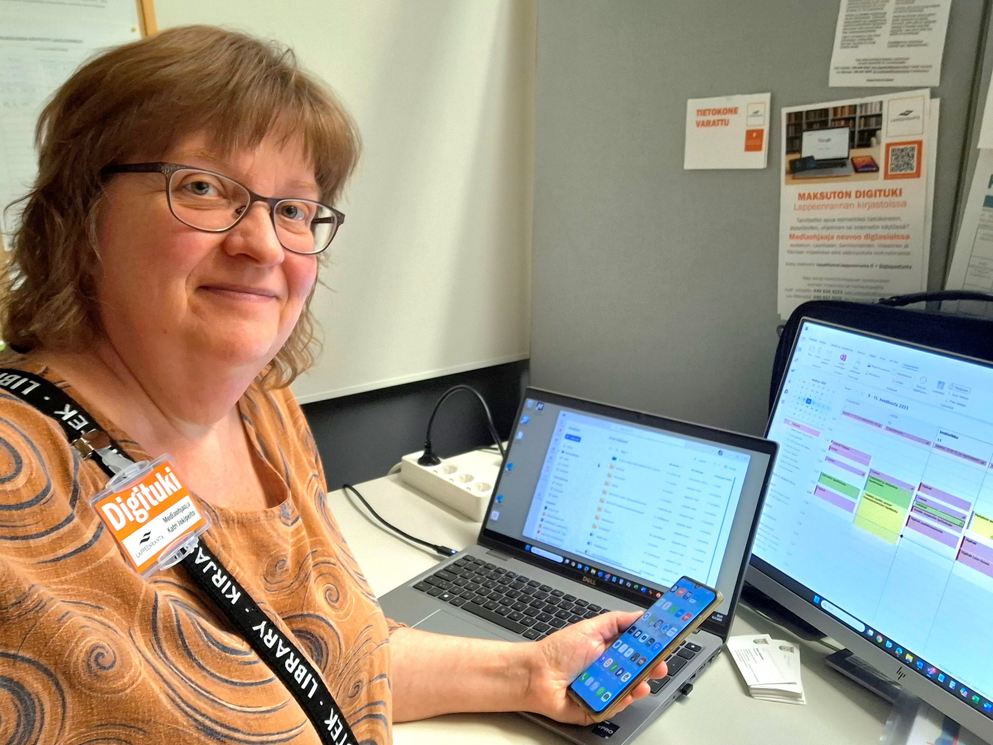 Digituen työntekijä työskentelee erilaisten digitaalisten laitteiden äärellä.